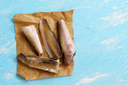 Raw frozen hake fish on a blue background. top view copy spaceの写真素材