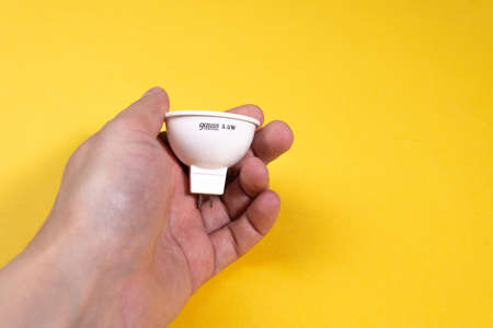 Tyumen, Russia-March 15, 2021: gauss led gu5. 3 elementary light bulb on yellow backgroundのeditorial素材
