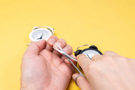 man cuts his nails. yellow background selective focus, copy spaceの写真素材