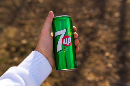 Tyumen, Russia-April 26, 2021: 7 up carbonated drink in hand on a blurry background. selective focus