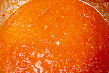 hot chili sauce is cooked on the stove. ketchup or tomato sauce or soup while cookingの写真素材