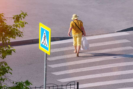 A woman crosses the road at a pedestrian crossing. Top viewの写真素材