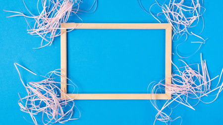 Wooden frame on blue background. Minimal border composition for your design. Copy space for text.の写真素材