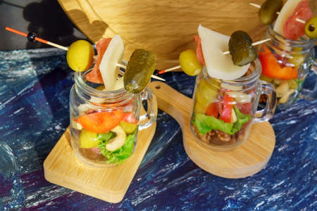 Glass jar jarcuterie nuts, olives, cheese, meat chips, salad. Healthy good carbs and fats, a light...