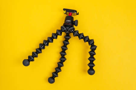 Tyumen, Russia-June 21, 2021: Flexible tripod Joby. Equipment for recording movies on a yellow background.のeditorial素材