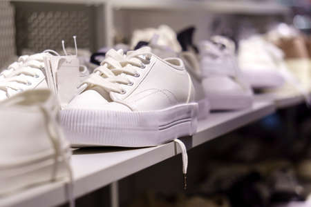 White sneakers on a white closet shelf. Selective focus. Buying shoesの写真素材