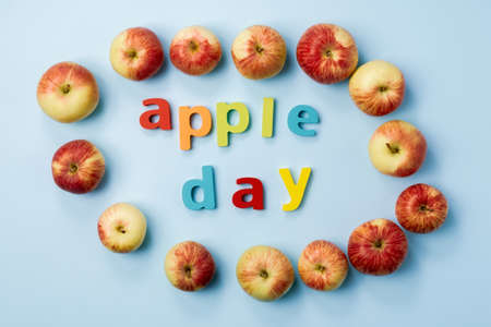 Apple is a national holiday on October 21. Red apples on a blue background. Flat lay.