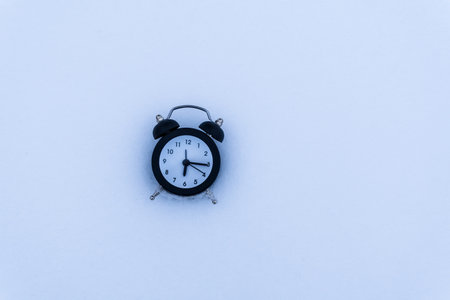 Alarm clock in the snow. New Year of winter concept. copy spaceの写真素材