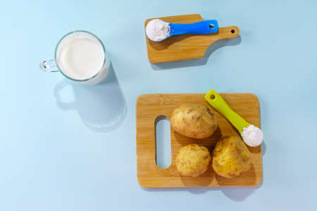 Powdered vegan potato milk. A glass of milk on a multicolored background