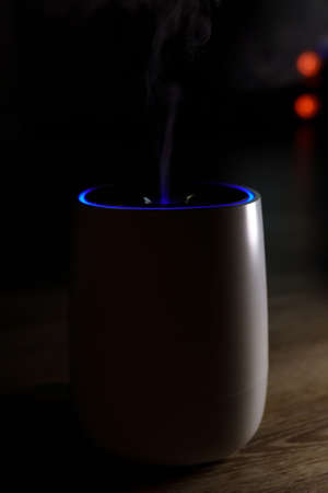 Used ultrasonic aromatherapy oil diffuser. Sprayed water droplets thrown into the air. Dark background, selective focusの写真素材