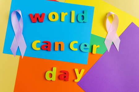 Text World Cancer Day ribbon on a multicolored surface background. Top viewの写真素材