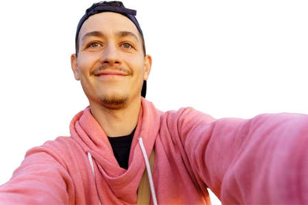 Young man takes a selfie on the front camera. Isolated on a white background