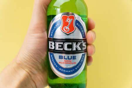 Tyumen, Russia-December 08, 2021: Bottle of Beks beer logo is non-alcoholic. Yellow backgroundのeditorial素材