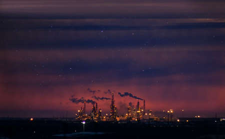 Smoke stack with smoke emission. Plant pipes pollute atmosphere. Industrial factory pollution. Night shootingの写真素材