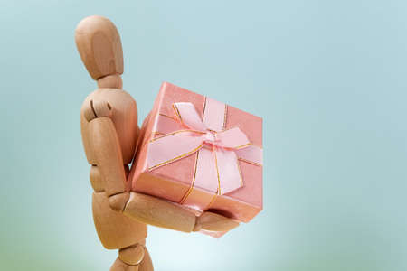 Online shopping, wooden mannequin with gifts. Online valentine, xmas shopping concept.の写真素材