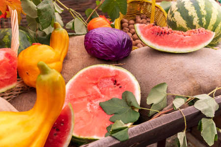 Various fruits, watermelons, pumpkins and vegetables on a cart during the autumn holiday. Selective...