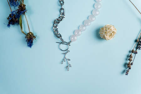 Handmade jewelery. Silver chain necklace and white quartz stones, on a blue backgroundの写真素材