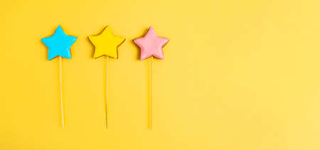 Colorful glazing cookies on a yellow background. Decorating desserts. cake decorating tools. Confectionery concept. flat lay. copy spaceの写真素材