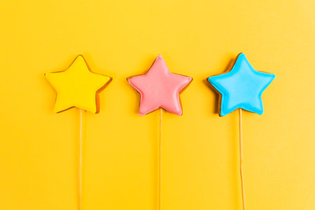 Colorful glazing cookies on a yellow background. Decorating desserts. Cake decorating tools. Confectionery concept. Flat lay.の写真素材