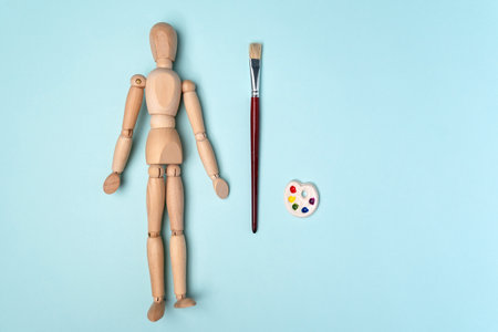 Artist paints with brushes and jars of paint on a yellow background. Accessories for artists. Lifestyle and hobby conceptの写真素材