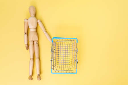 Mini cart supermarket with wooden mannequin Concept of delivery, online shopping. Copy space.の写真素材