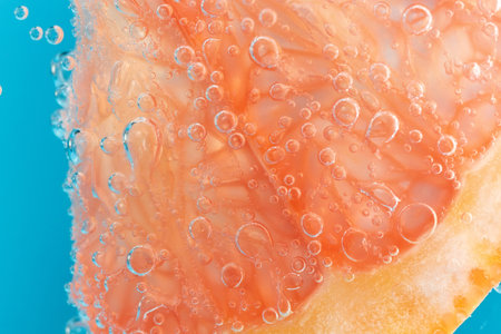 Grapefruit in the water under the water close-up macro. Background, fresh fruit. Selective focus.の写真素材