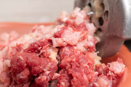 Meat grinder and mince comes out of it. Minced meat, meat delicacies, fresh home food. homemade food