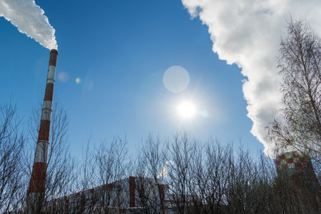 Steam from the pipes of the factory in the winter city. Powerful heating boiler room in winterの写真素材