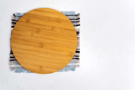 Round wooden cutting board on white concrete background. Flat layの写真素材