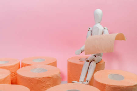 Roll of orange toilet paper on a pink background. hygiene products. copy spaceの写真素材