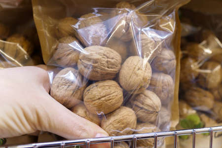 Pre packaged snacks walnuts on the shelves of the hypermarket. selective focus