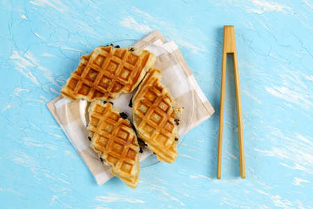 croffle with chocolate. A popular dish is a hybrid of croissant and waffle. blue background