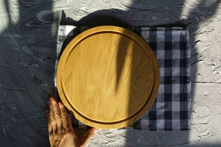 Wooden cutting board on a gray background. Rural catering dish for cutting pizza, bread, serving, top view. mockupの写真素材