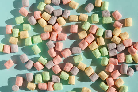 Multicolored marshmallows blue background, close-up. texture. Winter Sweets
