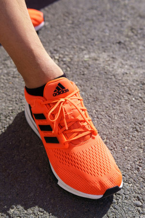 Tyumen, Russia-June 15, 2022: Adidas Running Shoes, orange coral color, eq21 run. Stylish street fashion. selective focusのeditorial素材