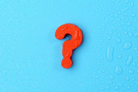 Big red question mark on a blue background. Copy the space, top view. water dropsの写真素材