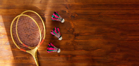 Badminton rackets and shuttlecock on wooden background top view space for text. badminton concept