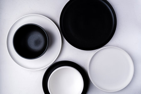 White and black food is an empty ceramic dish on a concrete background. top viewの写真素材