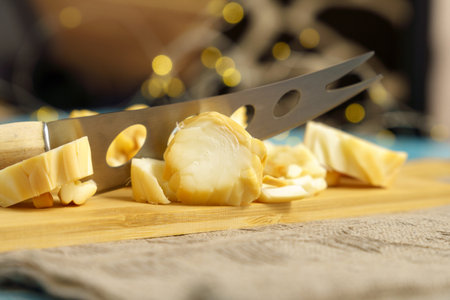 Cuts cheese in close-up with a cheese knife. selective focusの写真素材