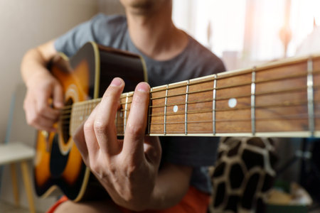 Man plays classical guitar sitting. Musician plays the guitar. selective focus