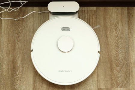 Tyumen, Russia-June 25, 2023: Honor Smart Robot Vacuum Cleaner CHOICE Robot Cleaner R2. Charging on the floorのeditorial素材
