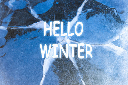 winter background. Hello Winter lettering. Crack on the ice, texture. Abstract winter background.の写真素材