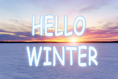 Hello Winter lettering. Winter nature and landscape. sunset sky and frozen ice lake. forest at horizon.の写真素材