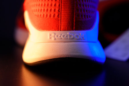 Tyumen, Russia-August 03, 2023: Reebok logo mens model Nanoflex in the red, blue light. Selective focusのeditorial素材