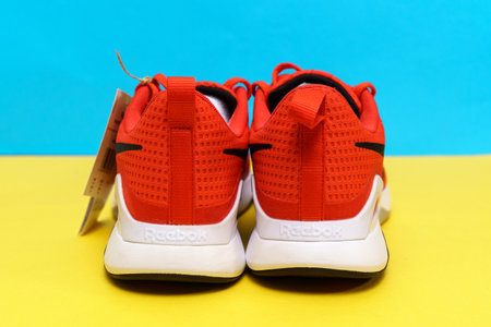 Tyumen, Russia-August 03, 2023: Modern red Reebok sneakers on the yellow and blue background. Nanoflex TR V2.のeditorial素材