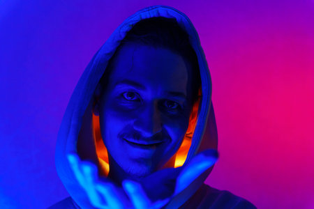 Neon light studio close-up portrait of a male model with a mustache and beard wearing sunglasses