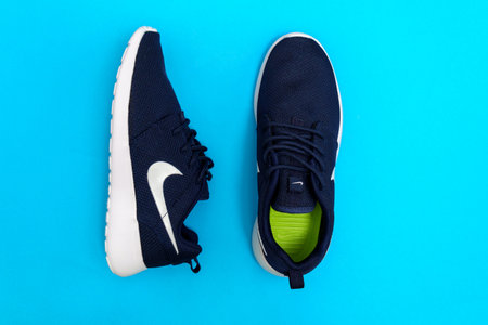 Tyumen, Russia-August 03, 2023: Nike sneakers for running, training, in blue background, showing the Nike logoのeditorial素材