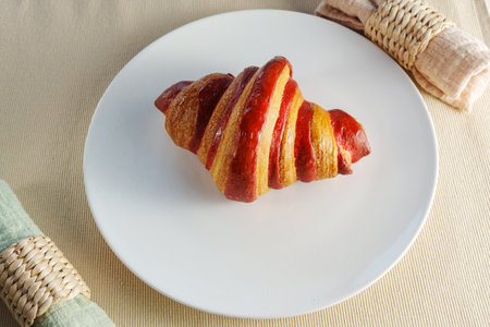Croissant vibrant piece of fruit, a succulent crimson strawberry, creating an ethereal and evocative composition.の写真素材