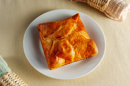 A visually stunning composition featuring a perfectly baked puff pastry adorning a pristine white...