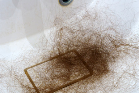 Close up reveals the challenges of an individual confronting hair loss. Selective focusの写真素材